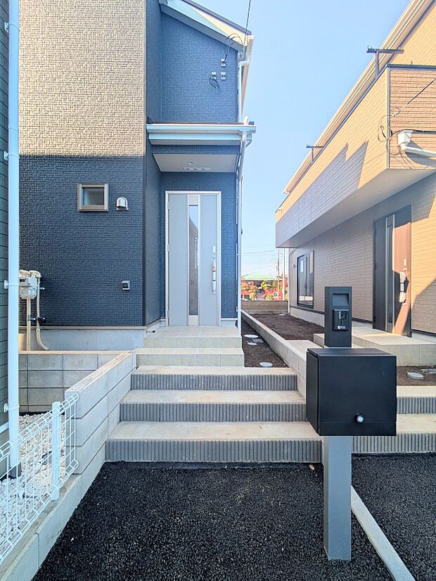 玄関へのアプローチ。居住者の帰り、訪れる方を優しく迎える・安らぎに満ちた生活空間を予感させる。健やかな暮らしを楽しめそう。