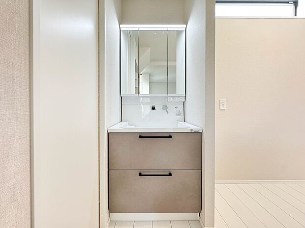 B号棟【洗面台】大きく見やすい三面鏡で清潔感ある洗面台は、身だしなみチェックや肌のお手入れに最適です。何かと物が増える場所だからこそ、スッキリと見映えの良い空間に拵えました。