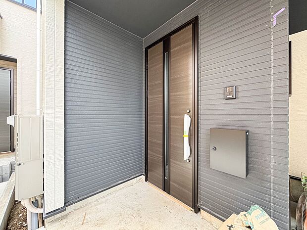 1号棟【玄関】玄関へ向かうまでのアプローチに漂う上質が期待感をもたせます。玄関は建物の顔。落着きを醸し出した自己主張が心に訴えてきます。