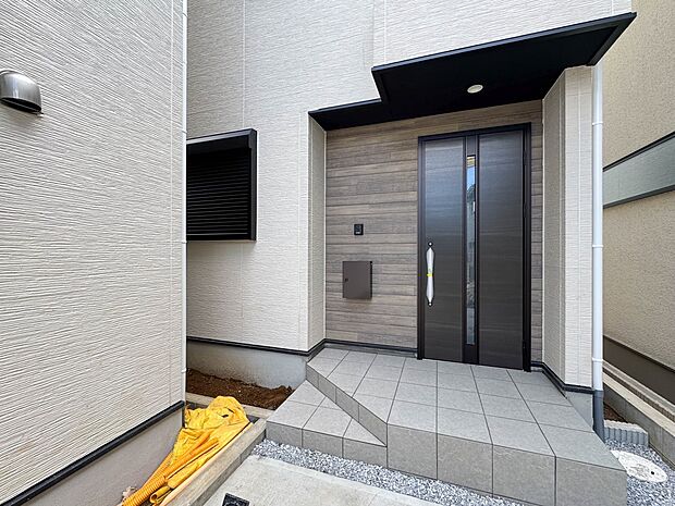 2号棟【玄関】玄関へ向かうまでのアプローチに漂う上質が期待感をもたせます。玄関は建物の顔。落着きを醸し出した自己主張が心に訴えてきます。