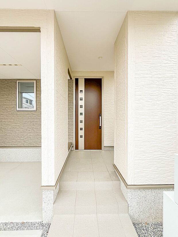 【玄関】玄関へ向かうまでのアプローチに漂う上質が期待感をもたせます。玄関は建物の顔。落着きを醸し出した自己主張が心に訴えてきます。