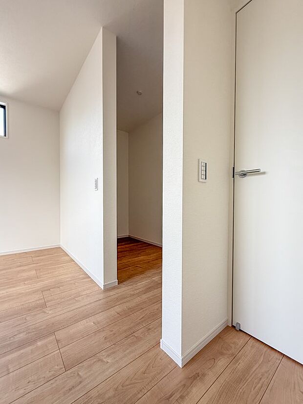 【ウォークインCL】清潔感のある白い壁と温かい木目調のフローリングが続く空間。奥へと誘うデザインは、家族の動線をスムーズにします。