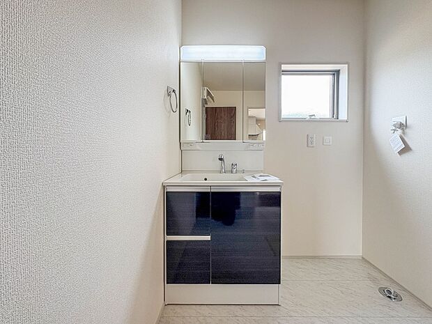 1号棟【三面鏡洗面化粧台】 ミラーを手前に引けば、楽な姿勢で髭剃りやメイクができます。合わせ鏡にすればヘアスタイルのチェックもラクラク。洗面化粧台のミラー裏にはたっぷり入る収納スペースを設…