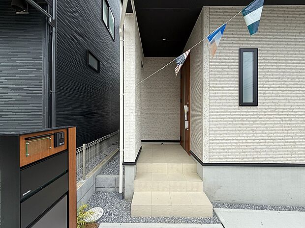 【玄関】玄関へのアプローチ。居住者の帰り、訪れる方を優しく迎える・安らぎに満ちた生活空間を予感させる。健やかな暮らしを楽しめそう。