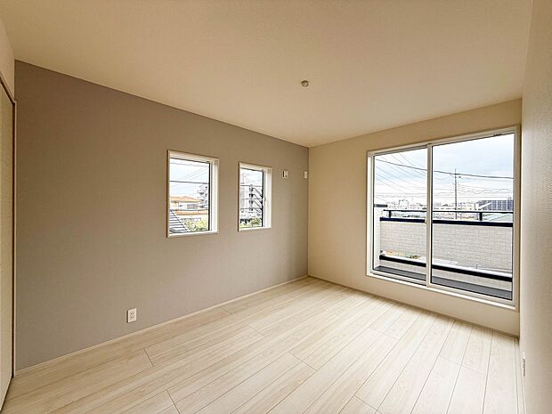 1号棟【 11.25帖 洋室】柔らかな陽光とフローリングの色味が調和した快適な空間。