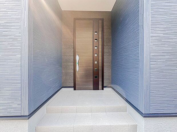 【玄関】玄関へ向かうまでのアプローチに漂う上質が期待感をもたせます。玄関は建物の顔。落着きを醸し出した自己主張が心に訴えてきます。