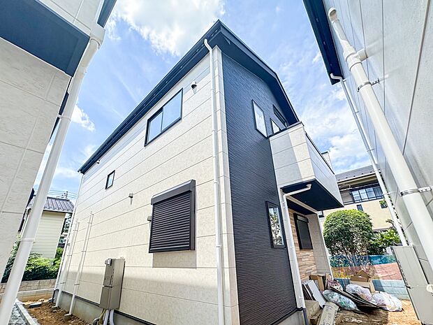 2号棟【現地外観】堂々たる趣ながら、主張し過ぎずどこか余裕を感じさせるシャープなフォルムで佇む邸宅は、晴天の空と照らし合わせる事で、本来あるべき完成形の姿を見せてくれます。