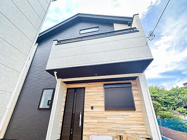 2号棟【現地外観】堂々たる趣ながら、主張し過ぎずどこか余裕を感じさせるシャープなフォルムで佇む邸宅は、晴天の空と照らし合わせる事で、本来あるべき完成形の姿を見せてくれます。