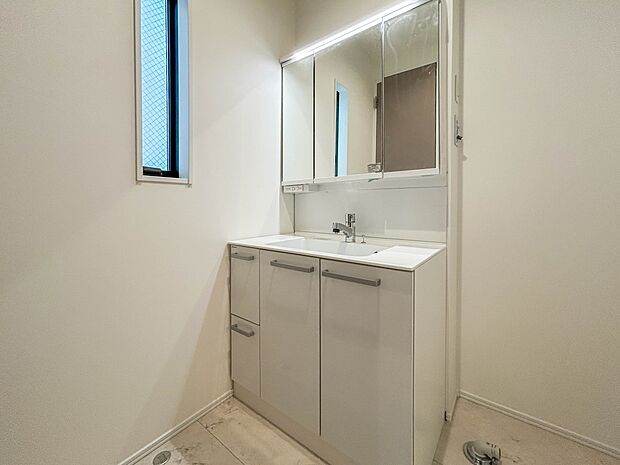 2号棟【三面鏡洗面化粧台】 ミラーを手前に引けば、楽な姿勢で髭剃りやメイクができます。合わせ鏡にすればヘアスタイルのチェックもラクラク。洗面化粧台のミラー裏にはたっぷり入る収納スペースを設…