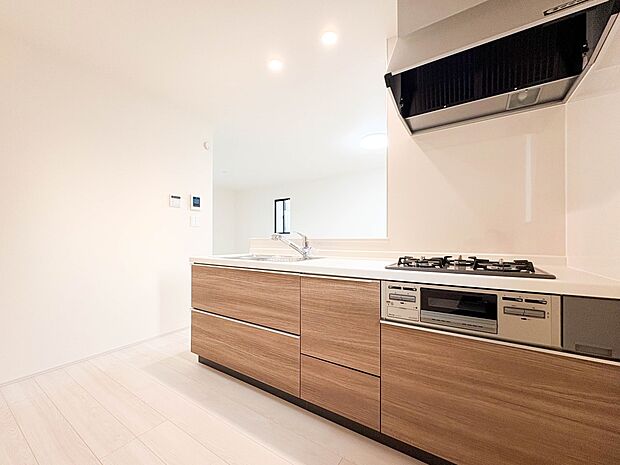 【LDK16.6帖】三口コンロで料理の幅を拡げてくれる使いやすいシステムキッチンを採用。洗い場も大きいので野菜や食器を洗ったりする際にも捗り、奥様の強い味方となってくれるはずです。