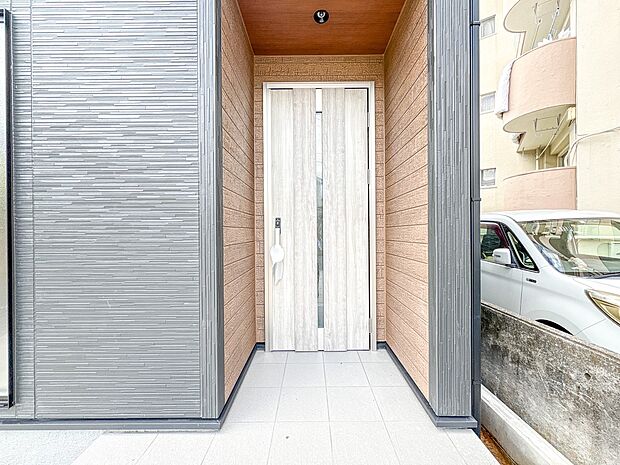 【玄関1号棟】玄関へ向かうまでのアプローチに漂う上質が期待感をもたせます。玄関は建物の顔。落着きを醸し出した自己主張が心に訴えてきます。