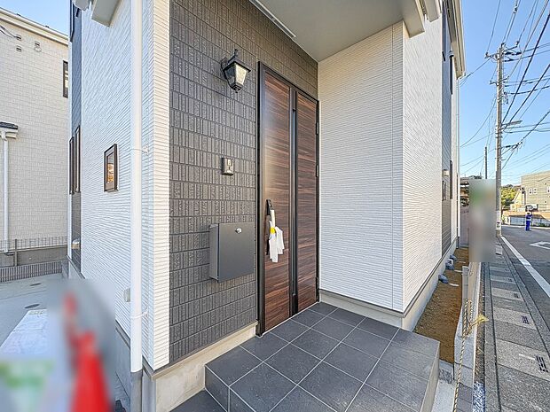 【玄関】玄関へ向かうまでのアプローチに漂う上質が期待感をもたせます。玄関は建物の顔。落着きを醸し出した自己主張が心に訴えてきます。