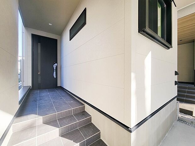 1号棟【玄関】玄関へ向かうまでのアプローチに漂う上質が期待感をもたせます。玄関は建物の顔。落着きを醸し出した自己主張が心に訴えてきます。