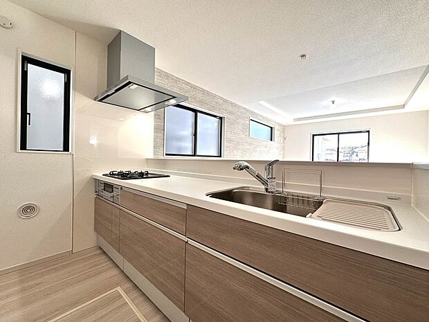 【キッチン】 三口コンロで料理の幅を拡げてくれる使いやすいシステムキッチンを採用。洗い場も大きいので野菜や食器を洗ったりする際にも捗り、奥様の強い味方となってくれるはずです。