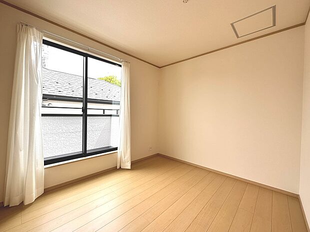 【洋室5.25帖】柔らかな陽光とフローリングの色味が調和した快適な空間。