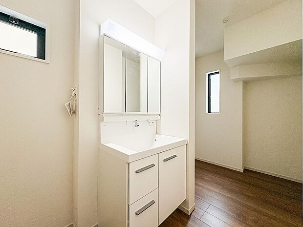 1号棟【洗面台】大きく見やすい三面鏡で清潔感ある洗面台は、身だしなみチェックや肌のお手入れに最適です。何かと物が増える場所だからこそ、スッキリと見映えの良い空間に拵えました。