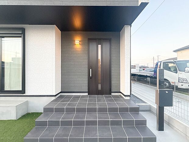 D号棟【玄関】玄関へ向かうまでのアプローチに漂う上質が期待感をもたせます。玄関は建物の顔。落着きを醸し出した自己主張が心に訴えてきます。