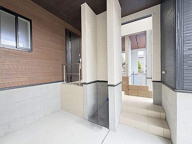 【1号棟 外観】ビルトインの車庫スペースと玄関エントランス・南向きの建物