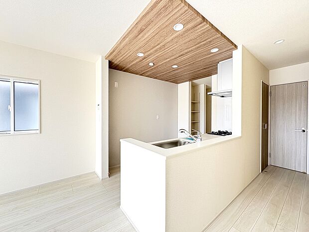 【1号棟 LDK19.8帖】天井のアクセントクロスとLED照明でデザインされたキッチンスペース