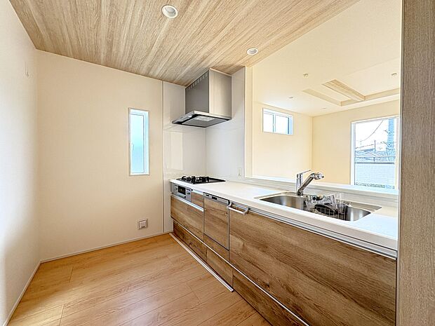 【2号棟 キッチン】天井にアクセントクロスとLED照明・デザイン性豊かな広々空間・食洗器完備のシステムキッチン