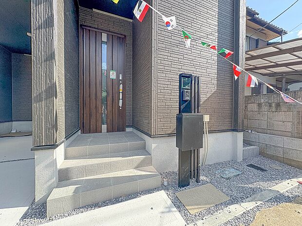 1号棟【外観】街の風景に溶けこむシンプルなカタチ。バランスがとれた玄関のハイクォリティなデザイン。存在感あふれる建物の質感。