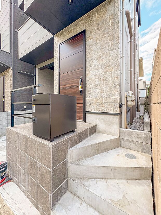 【玄関】玄関へ向かうまでのアプローチに漂う上質が期待感をもたせます。玄関は建物の顔。落着きを醸し出した自己主張が心に訴えてきます。