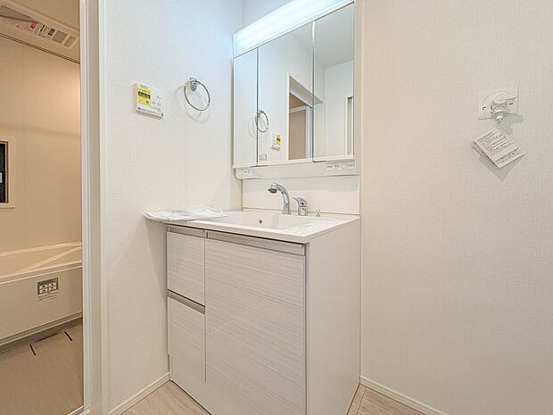 12号棟【三面鏡洗面化粧台】  ミラーを手前に引けば、楽な姿勢で髭剃りやメイクができます。合わせ鏡にすればヘアスタイルのチェックもラクラク。洗面化粧台のミラー裏にはたっぷり入る収納スペースを…