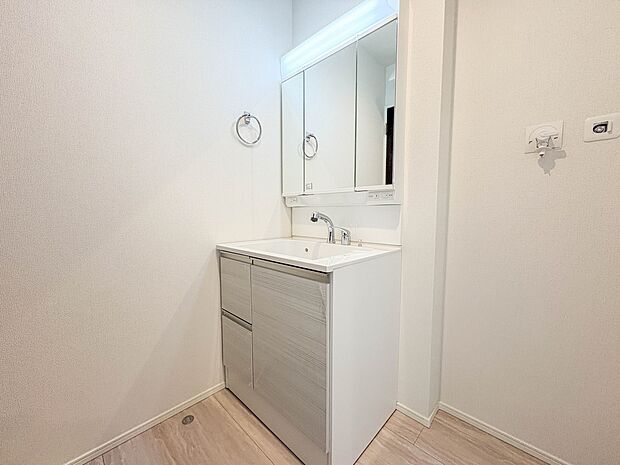 8号棟【洗面台】大きく見やすい三面鏡で清潔感ある洗面台は、身だしなみチェックや肌のお手入れに最適です。何かと物が増える場所だからこそ、スッキリと見映えの良い空間に拵えました。