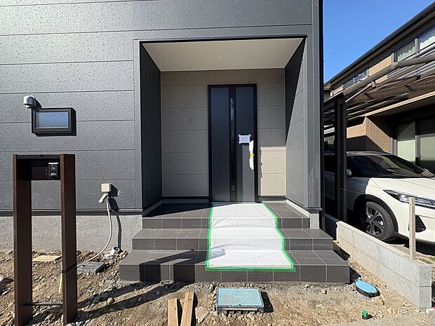 【玄関】玄関へ向かうまでのアプローチに漂う上質が期待感をもたせます。玄関は建物の顔。落着きを醸し出した自己主張が心に訴えてきます。