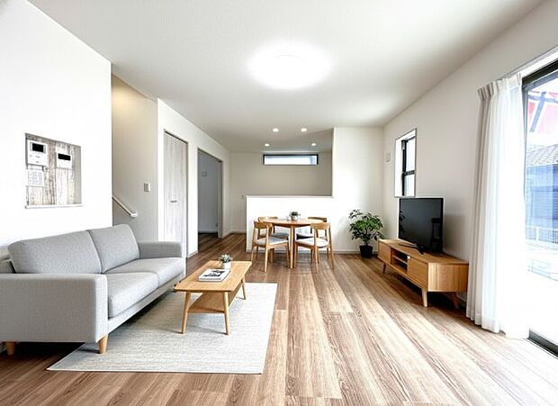 【C号棟 LDK16.7帖】キッチン横に4.5帖の洋室・リビング南側に駐車スペースと隣地通路、日当たり良好リビング＊AIによる家具や植栽を配置しています。販売価格に含みません