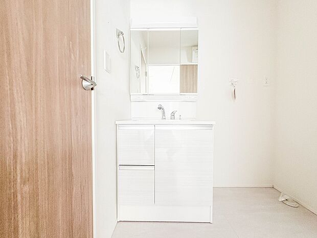 2号棟【三面鏡洗面化粧台】  ミラーを手前に引けば、楽な姿勢で髭剃りやメイクができます。合わせ鏡にすればヘアスタイルのチェックもラクラク。洗面化粧台のミラー裏にはたっぷり入る収納スペースを設…