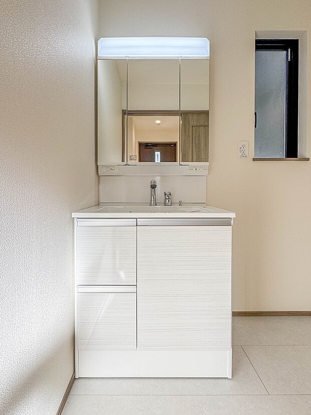 【洗面所】大きく見やすい三面鏡で清潔感ある洗面台は、身だしなみチェックや肌のお手入れに最適です。何かと物が増える場所だからこそ、スッキリと見映えの良い空間に拵えました。