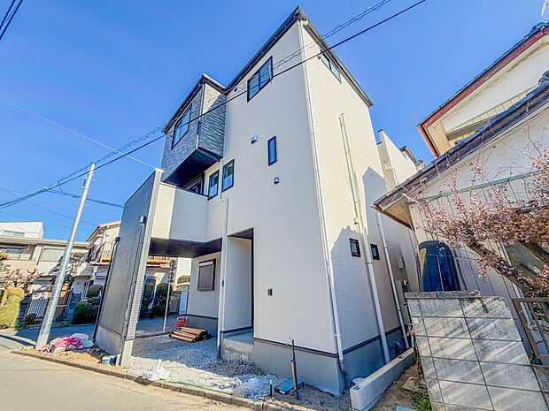 【現地外観-1号棟-】堂々たる趣ながら、主張し過ぎずどこか余裕を感じさせるシャープなフォルムで佇む邸宅は、晴天の空と照らし合わせる事で、本来あるべき完成形の姿を見せてくれます。