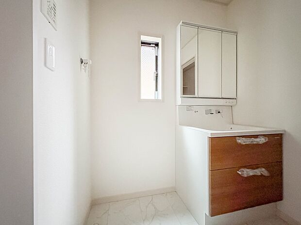 2号棟【三面鏡洗面化粧台】  ミラーを手前に引けば、楽な姿勢で髭剃りやメイクができます。合わせ鏡にすればヘアスタイルのチェックもラクラク。洗面化粧台のミラー裏にはたっぷり入る収納スペースを設…