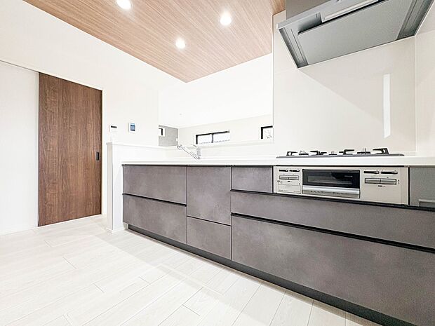 【キッチン】三口コンロで料理の幅を拡げてくれる使いやすいシステムキッチンを採用。洗い場も大きいので野菜や食器を洗ったりする際にも捗り、奥様の強い味方となってくれるはずです。