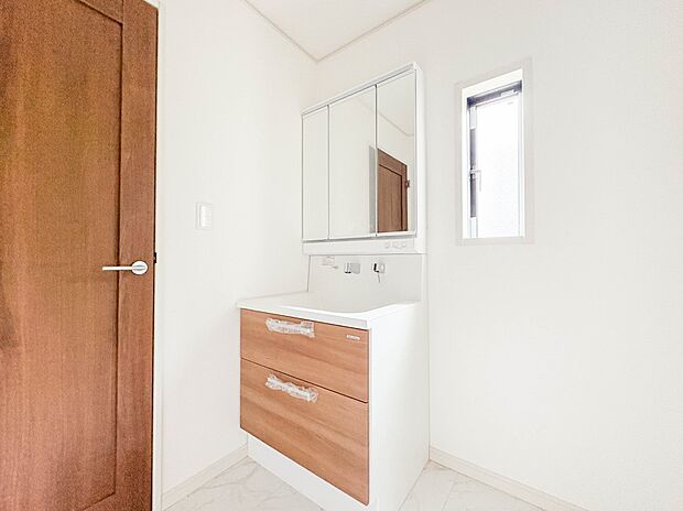 1号棟【三面鏡洗面化粧台】  ミラーを手前に引けば、楽な姿勢で髭剃りやメイクができます。合わせ鏡にすればヘアスタイルのチェックもラクラク。洗面化粧台のミラー裏にはたっぷり入る収納スペースを設…