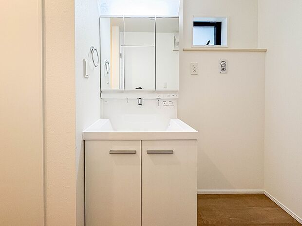 1号棟【三面鏡洗面化粧台】  ミラーを手前に引けば、楽な姿勢で髭剃りやメイクができます。合わせ鏡にすればヘアスタイルのチェックもラクラク。洗面化粧台のミラー裏にはたっぷり入る収納スペースを設…