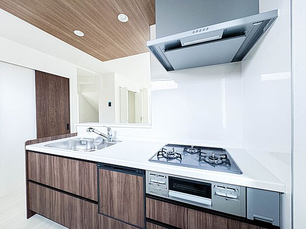 【キッチン】三口コンロで料理の幅を拡げてくれる使いやすいシステムキッチンを採用。洗い場も大きいので野菜や食器を洗ったりする際にも捗り、奥様の強い味方となってくれるはずです。