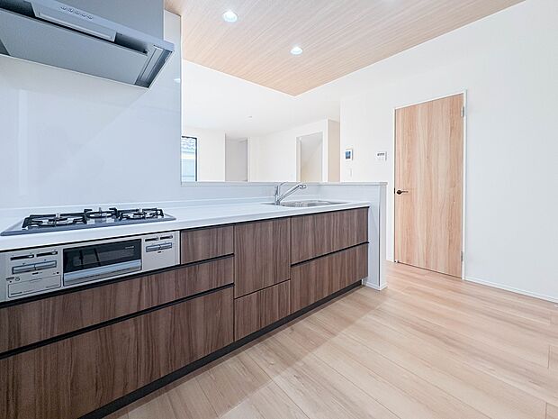 【キッチン】 三口コンロで料理の幅を拡げてくれる使いやすいシステムキッチンを採用。洗い場も大きいので野菜や食器を洗ったりする際にも捗り、奥様の強い味方となってくれるはずです。