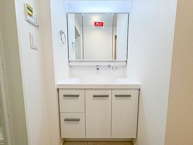 2号棟【三面鏡洗面化粧台】 ミラーを手前に引けば、楽な姿勢で髭剃りやメイクができます。合わせ鏡にすればヘアスタイルのチェックもラクラク。洗面化粧台のミラー裏にはたっぷり入る収納スペースを設…