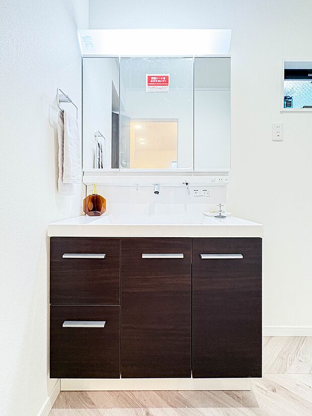 【洗面所】大きく見やすい三面鏡で清潔感ある洗面台は、身だしなみチェックや肌のお手入れに最適です。何かと物が増える場所だからこそ、スッキリと見映えの良い空間に拵えました。