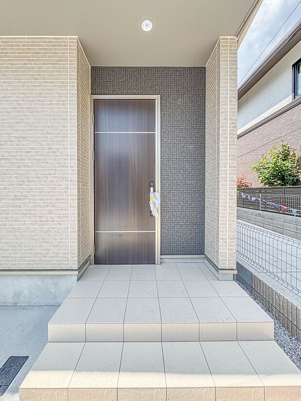 F号棟【玄関】玄関へ向かうまでのアプローチに漂う上質が期待感をもたせます。玄関は建物の顔。落着きを醸し出した自己主張が心に訴えてきます。