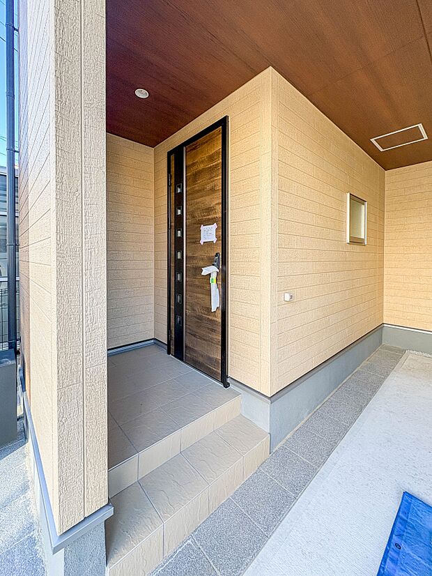 【玄関】玄関へ向かうまでのアプローチに漂う上質が期待感をもたせます。玄関は建物の顔。落着きを醸し出した自己主張が心に訴えてきます。