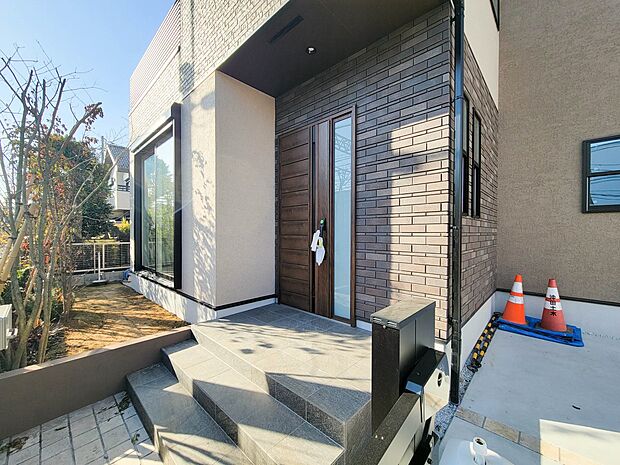 1号棟【玄関】玄関へ向かうまでのアプローチに漂う上質が期待感をもたせます。玄関は建物の顔。落着きを醸し出した自己主張が心に訴えてきます。