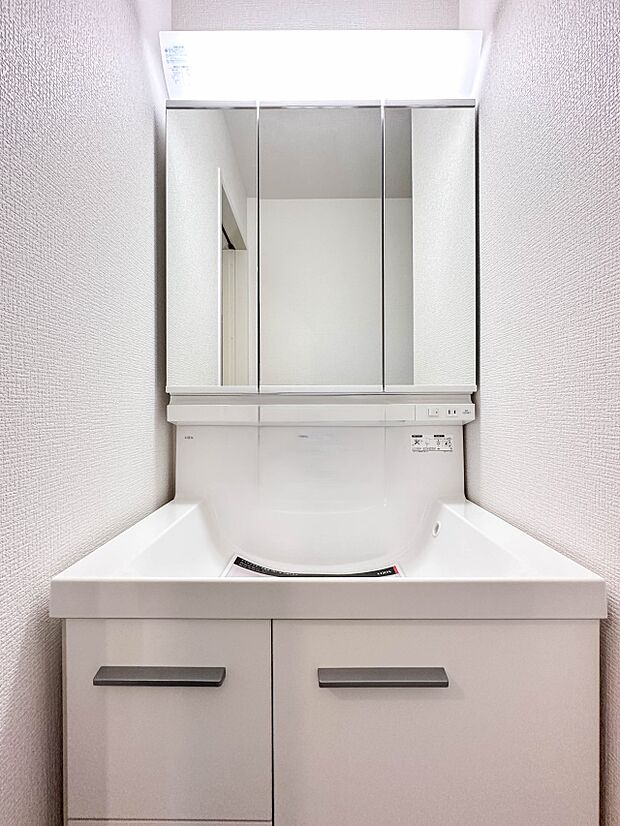 【洗面台】大きく見やすい三面鏡で清潔感ある洗面台は、身だしなみチェックや肌のお手入れに最適です。何かと物が増える場所だからこそ、スッキリと見映えの良い空間に拵えました。