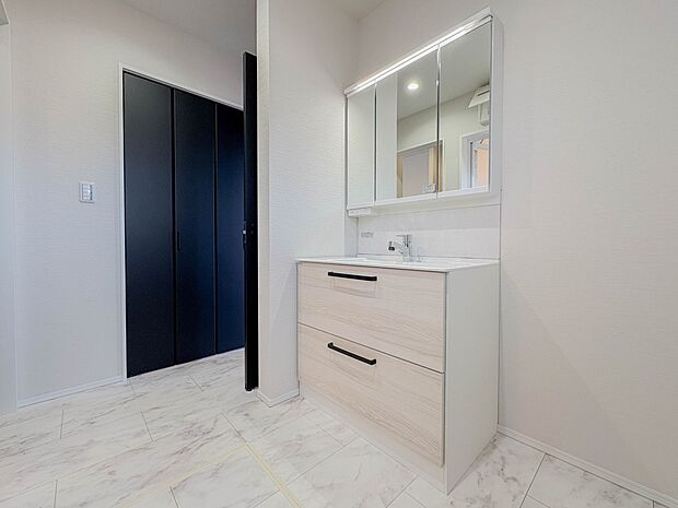 【洗面所】大きく見やすい三面鏡で清潔感ある洗面台は、身だしなみチェックや肌のお手入れに最適です。何かと物が増える場所だからこそ、スッキリと見映えの良い空間に拵えました。