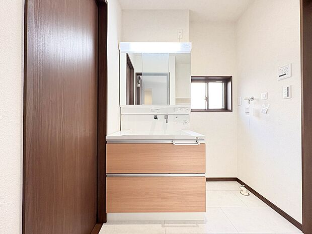 【洗面台】大きく見やすい三面鏡で清潔感ある洗面台は、身だしなみチェックや肌のお手入れに最適です。何かと物が増える場所だからこそ、スッキリと見映えの良い空間に拵えました。