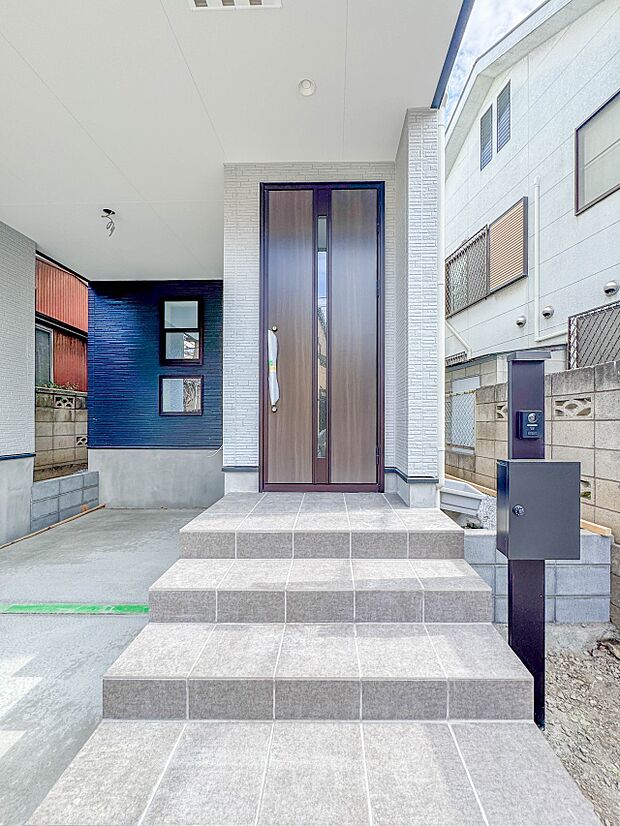 【玄関】玄関へ向かうまでのアプローチに漂う上質が期待感をもたせます。玄関は建物の顔。落着きを醸し出した自己主張が心に訴えてきます。