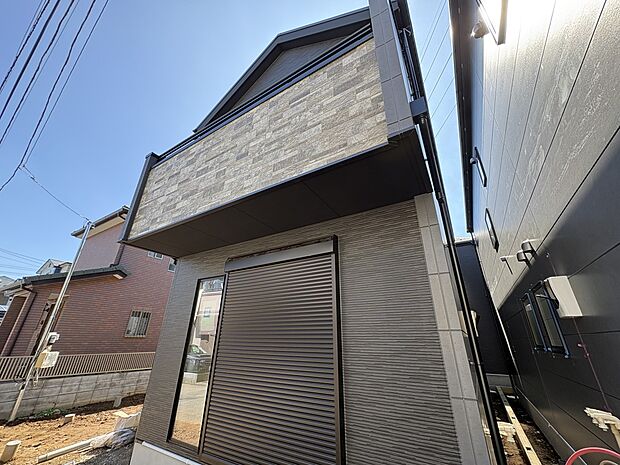 2号棟【現地外観】堂々たる趣ながら、主張し過ぎずどこか余裕を感じさせるシャープなフォルムで佇む邸宅は、晴天の空と照らし合わせる事で、本来あるべき完成形の姿を見せてくれます。