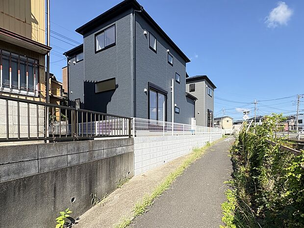 【現地外観】河川に近い立地ですが、対岸や南側と比較し高台に位置する現地・北東側 遊歩道からの外観(写真 奥1号棟 手前2号棟
